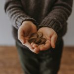 Hand holding coins tactile discrimination